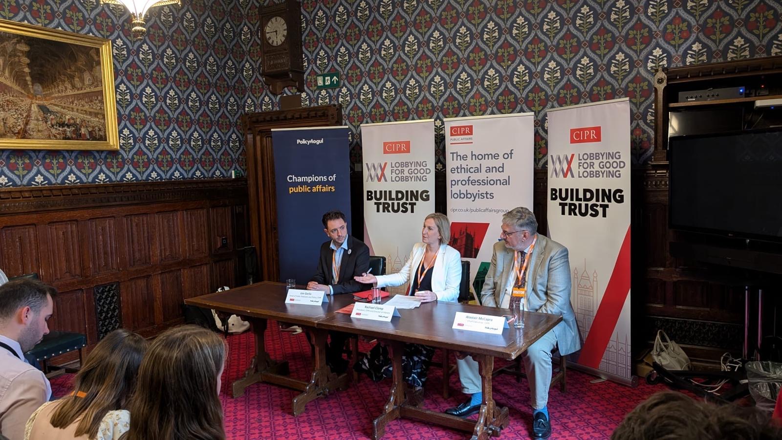 CIPR 2024 President Rachael Clamp, CEO Alastair McCapra, and Head of PR and Policy Jon Gerlis, sat at a panel in the House of Comms decorated room. Banners promoting the CIPR’s Lobbying for Good Lobbying campaign sit behind them.